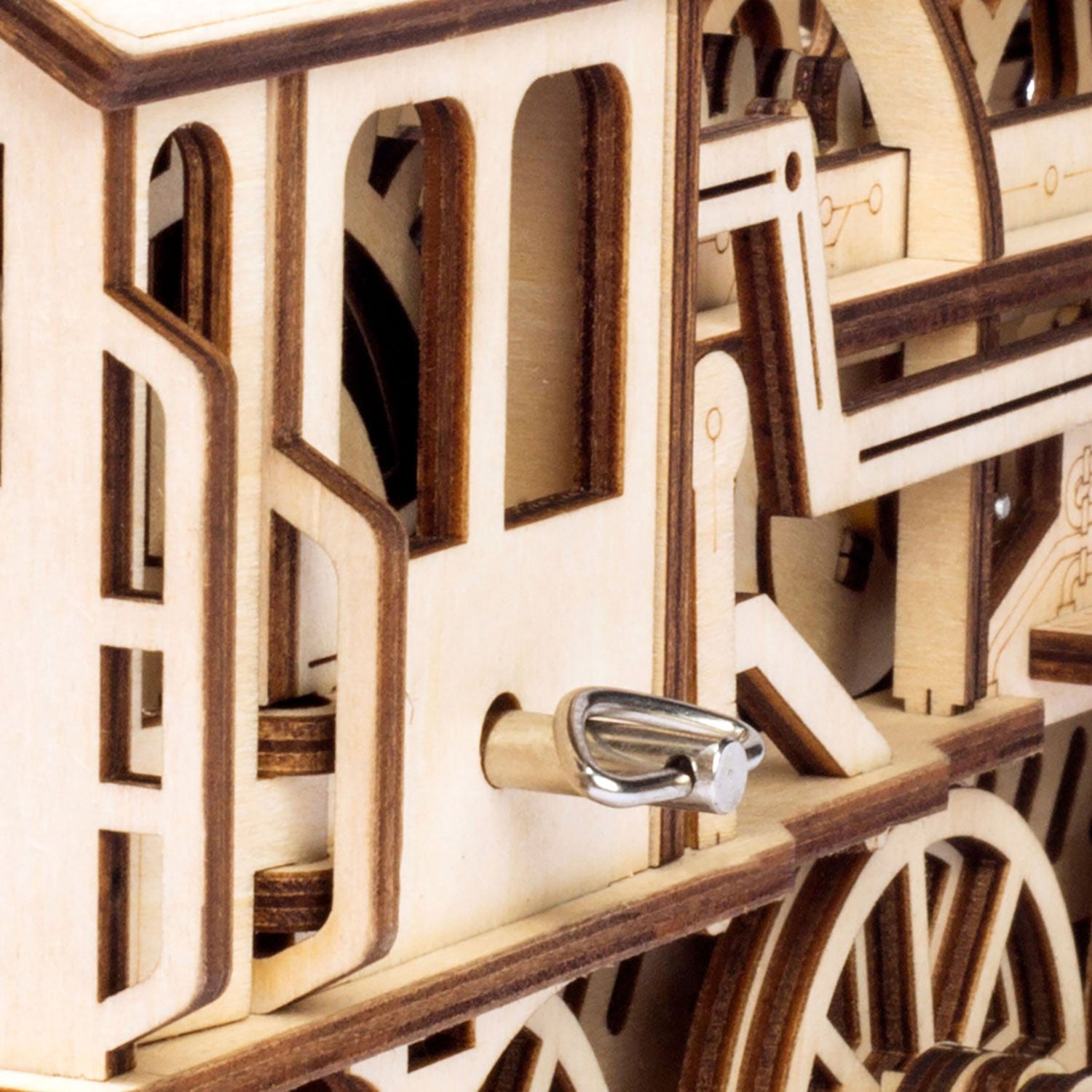 Nahaufnahme eines detaillierten Holzmodells, das einer historischen Lokomotive ähnelt, ähnlich dem 3D-Holzpuzzle Mechanische Dampf Express Eisenbahn. Es verfügt über komplizierte Zahnräder und Räder mit geschichteten Teilen und präzisen Ausschnitten, ideal für Enthusiasten, die gerne Dampflokomotiven bauen.