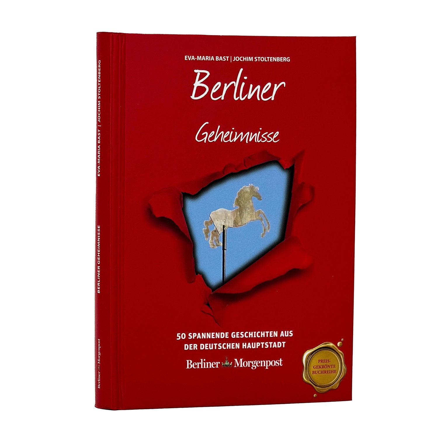 Das rote Buch „Berliner Geheimnisse“ zeigt auf dem Cover eine weiße Pferdekarussellfigur und enthält „50 spannende Geschichten aus der deutschen Hauptstadt“ mit „Berliner Morgenpost“ am unteren Ende. Es ist mit einem goldenen Siegel geschmückt und mit den geheimnisvollen Relikten Berlins gefüllt.