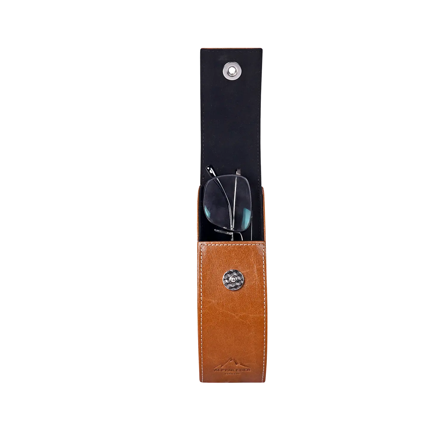 Das Brillenetui „GLUST“ ist ein braunes Büffelleder-Brillenetui im eleganten, vertikalen Design. Es öffnet sich über eine Klappe und gibt den Blick auf die schwarze Brille frei. An der Unterseite befindet sich ein silberner Knopf mit dem GLUST-Logo.