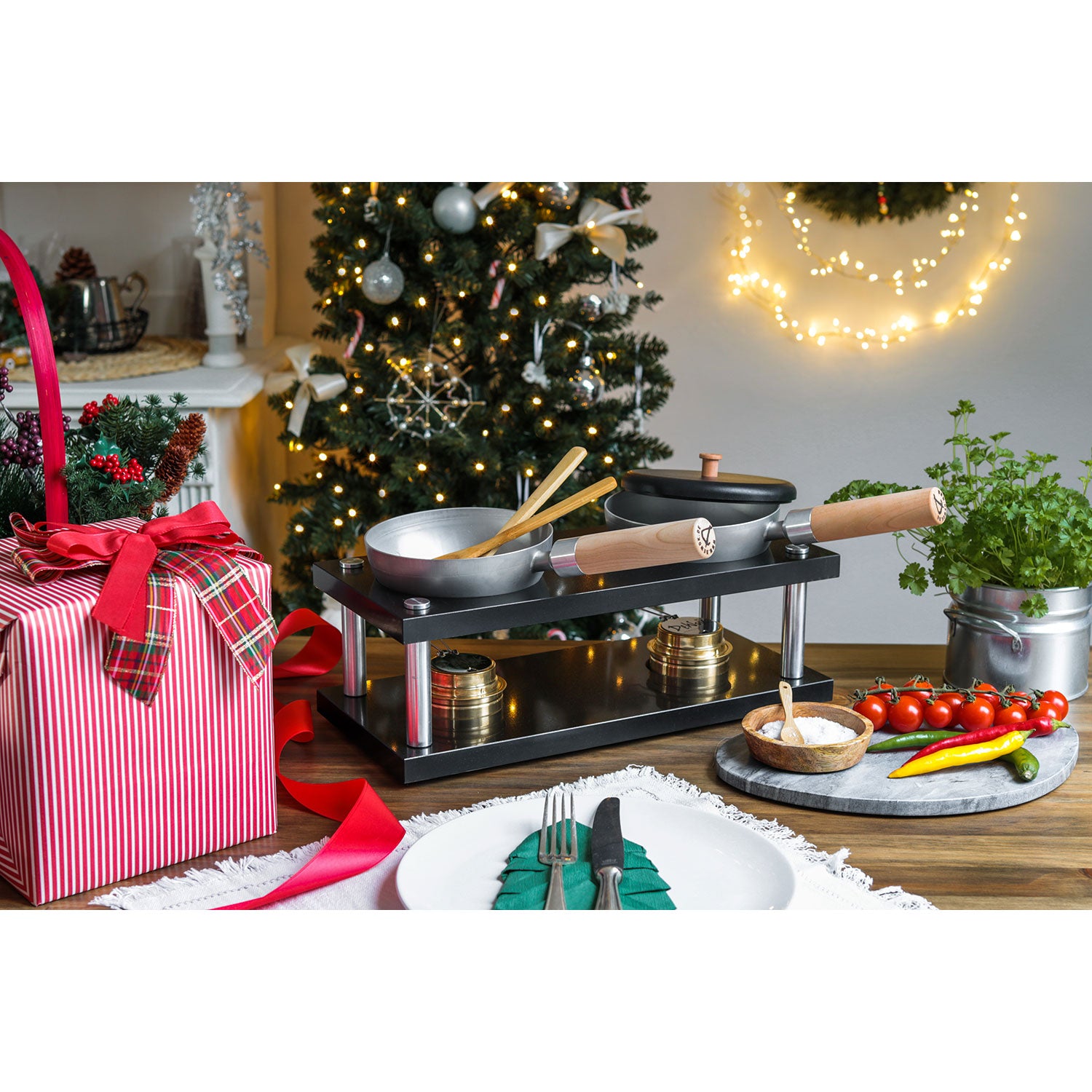 Ein geschmückter Weihnachtsbaum und funkelnde Lichter sorgen für eine festliche Weihnachtsstimmung. Das DeWok Kochsystem sorgt für ein Fondue-Set mit frischen Kräutern, Tomaten und Paprika auf dem Tisch. Ein verpacktes Geschenk lädt zu einem Soulfood-Moment im gemütlichen Essbereich ein.