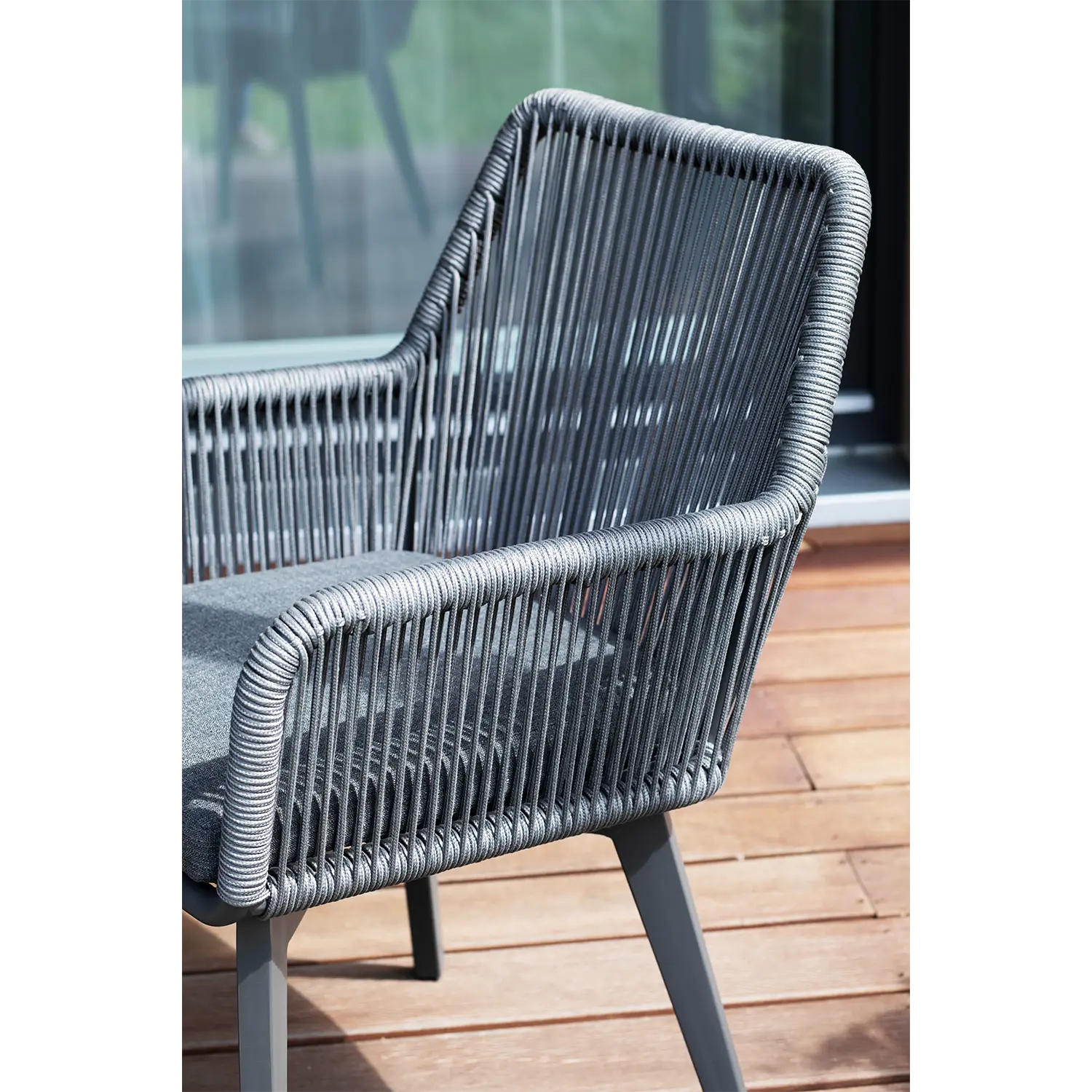 Das Diningsessel Marbella Rope 2er Set ist eine moderne Sitzgelegenheit für den Außenbereich mit elegantem Flechtdesign und grauen Seilen, ideal für den Einsatz im Freien. Mit weichen grauen Kissen und wetterfester Konstruktion bietet es Komfort und Zuverlässigkeit direkt vor dem Glasfenster Ihrer Terrasse.