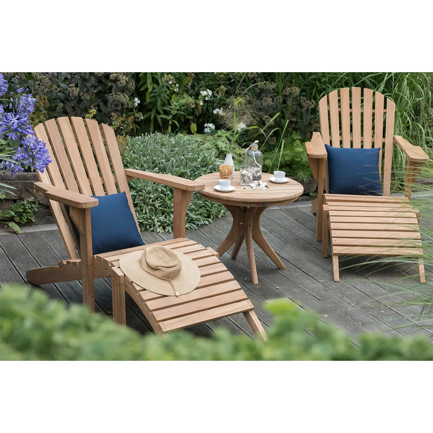 Zwei Gartenlounger Adirondack auf Terrasse mit blauen Kissen und Beistelltisch