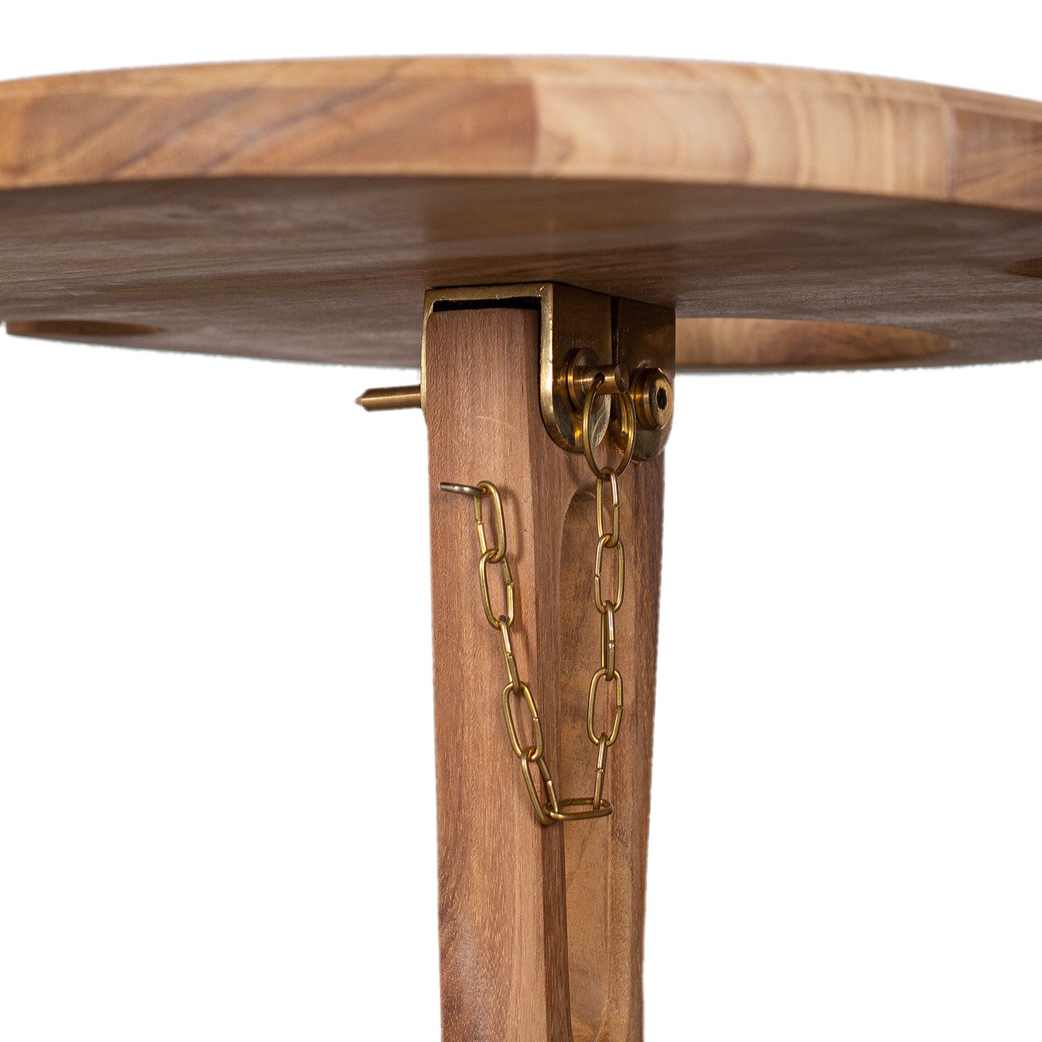 Nahaufnahme eines Getränkehalter-Spieß mit einem edlen Tischbein aus Teakholz mit Messinggelenk und Kette; die Kette befestigt ihn an der glatten, runden Tischplatte und unterstreicht sein faltbares Design.