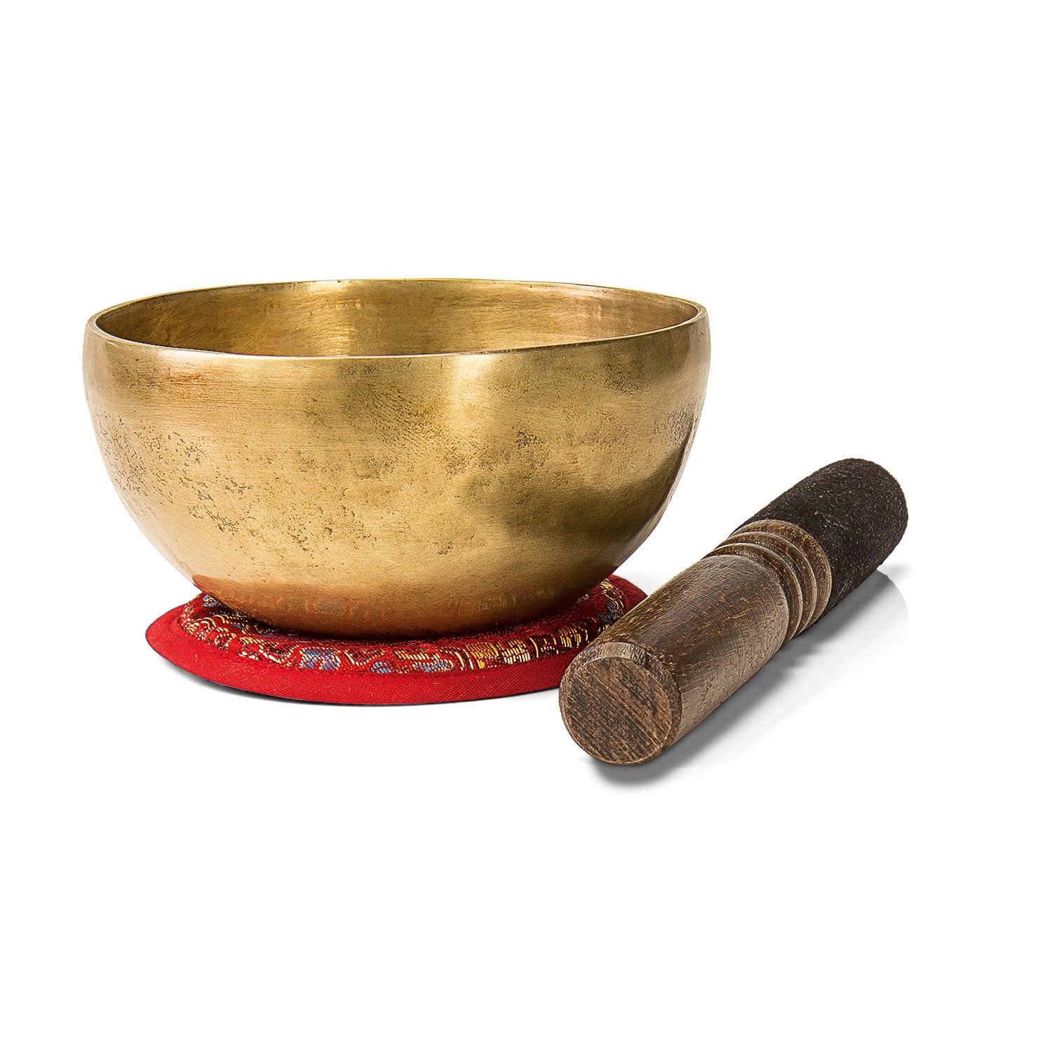 Die Klangschale „Tao“, eine goldene, handgehämmerte Schale aus Nepal, steht auf einem gemusterten roten Kissen mit einem Holzhammer daneben und bildet einen eleganten Kontrast vor einem makellos weißen Hintergrund.