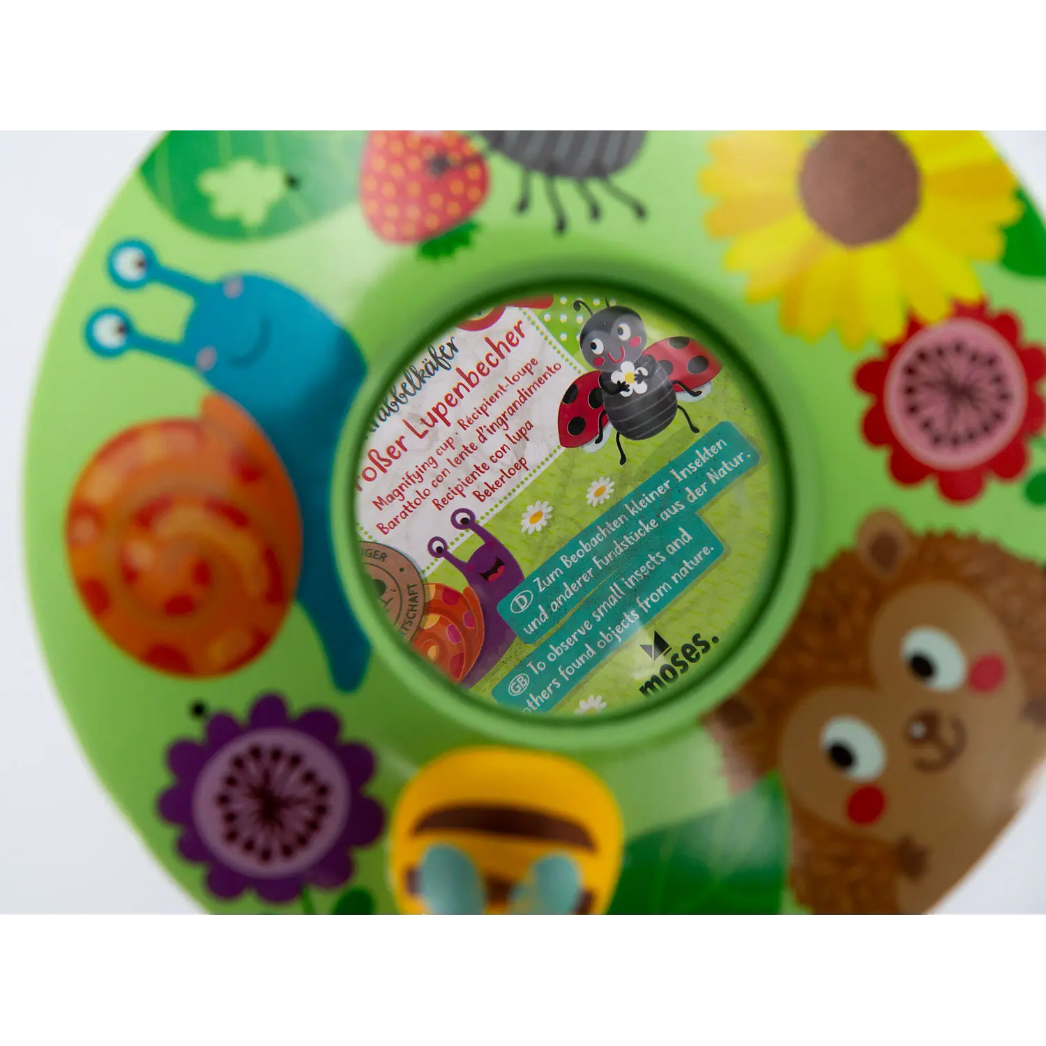 Der Krabbelkäfer Lupenbecher aus Holz für Kinder ist ein farbenfrohes Kinderspielzeug mit kindgerechtem Design. Er zeigt illustrierte Tiere wie eine Schnecke, einen Marienkäfer und einen Igel. Auf einem zentralen runden Bildschirm ist deutscher Text in verspielter Schriftart zu sehen, umgeben von Blumen und Pilzen.