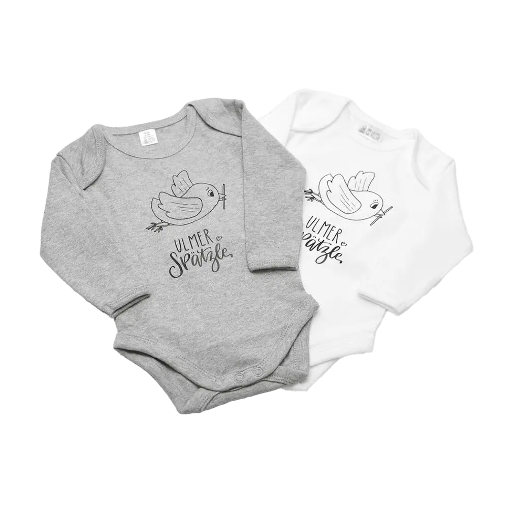 Zwei Langarm-Bodies „Ulmer Spätzle“ aus Biobaumwolle in Grau und Weiß mit handgezeichnetem Vogel, Zweig und dem Schriftzug „ULMER Spätzle“ im Handlettering-Stil auf der Vorderseite.