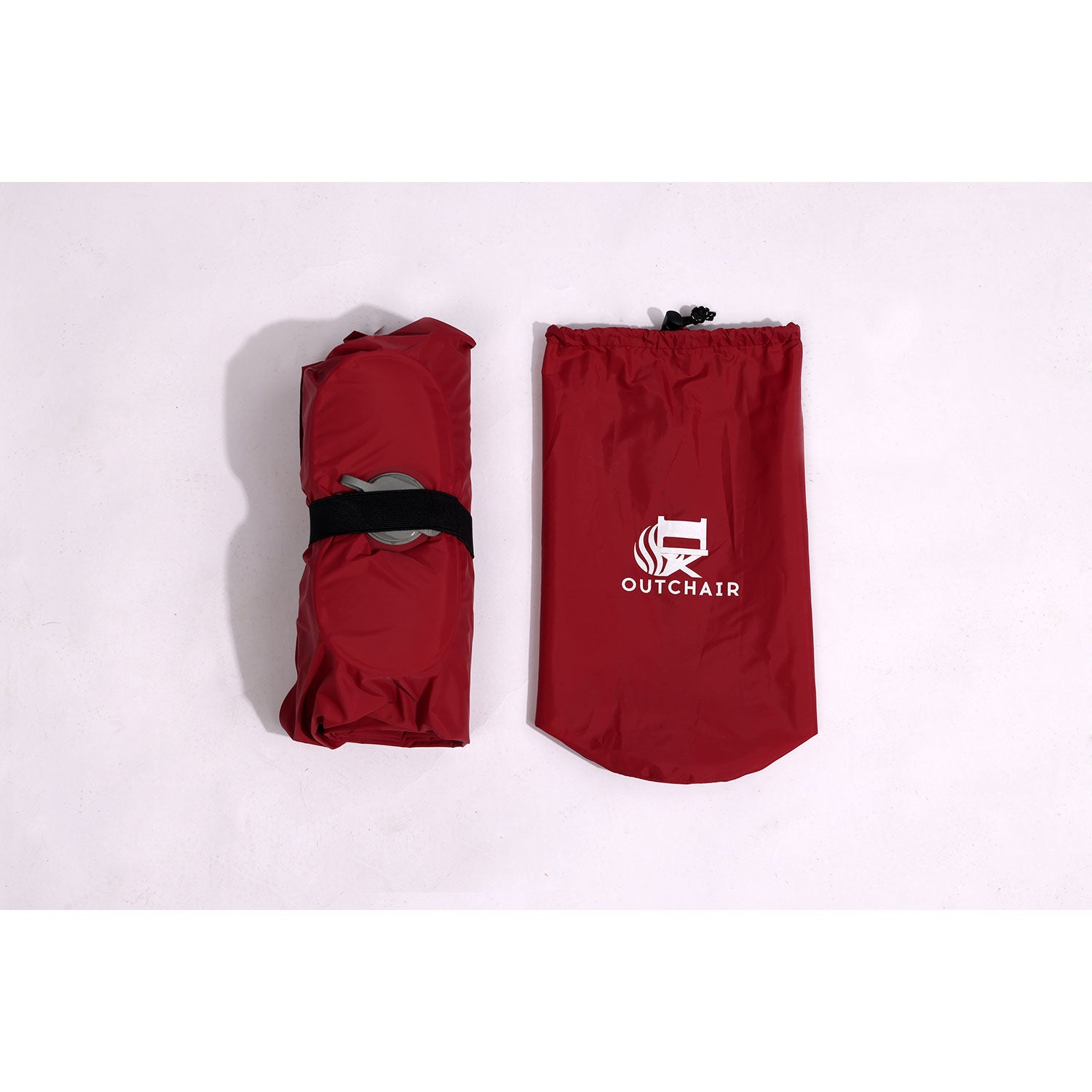 Ein roter, tragbarer Stuhl mit der Aufschrift „OUTCHAIR“ eignet sich in der zusammengeklappten Version perfekt zum Camping. Sein schlankes Design, ähnlich dem Komfort einer Luftmatratze mit Aufpumpfunktion, bietet Komfort beim Transport und Einsatz auf jedem Gelände.