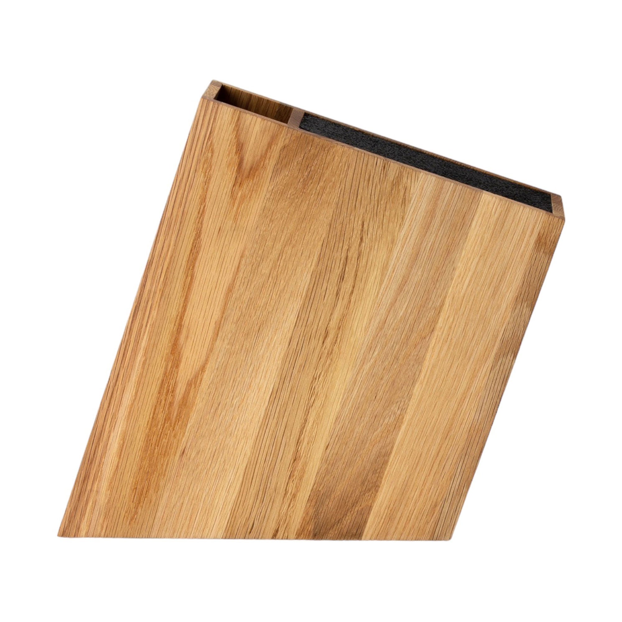 Der Messerblock mit flexiblem Einsatz Eiche ist ein aus Massivhölzern gefertigter Messerblock mit schrägem Design, das die natürliche Holzmaserung optimal zur Geltung bringt. Der vertikale, offene Schlitz ermöglicht einen einfachen Zugriff auf das Messer und setzt sich elegant vor einem schlichten weißen Hintergrund in Szene.