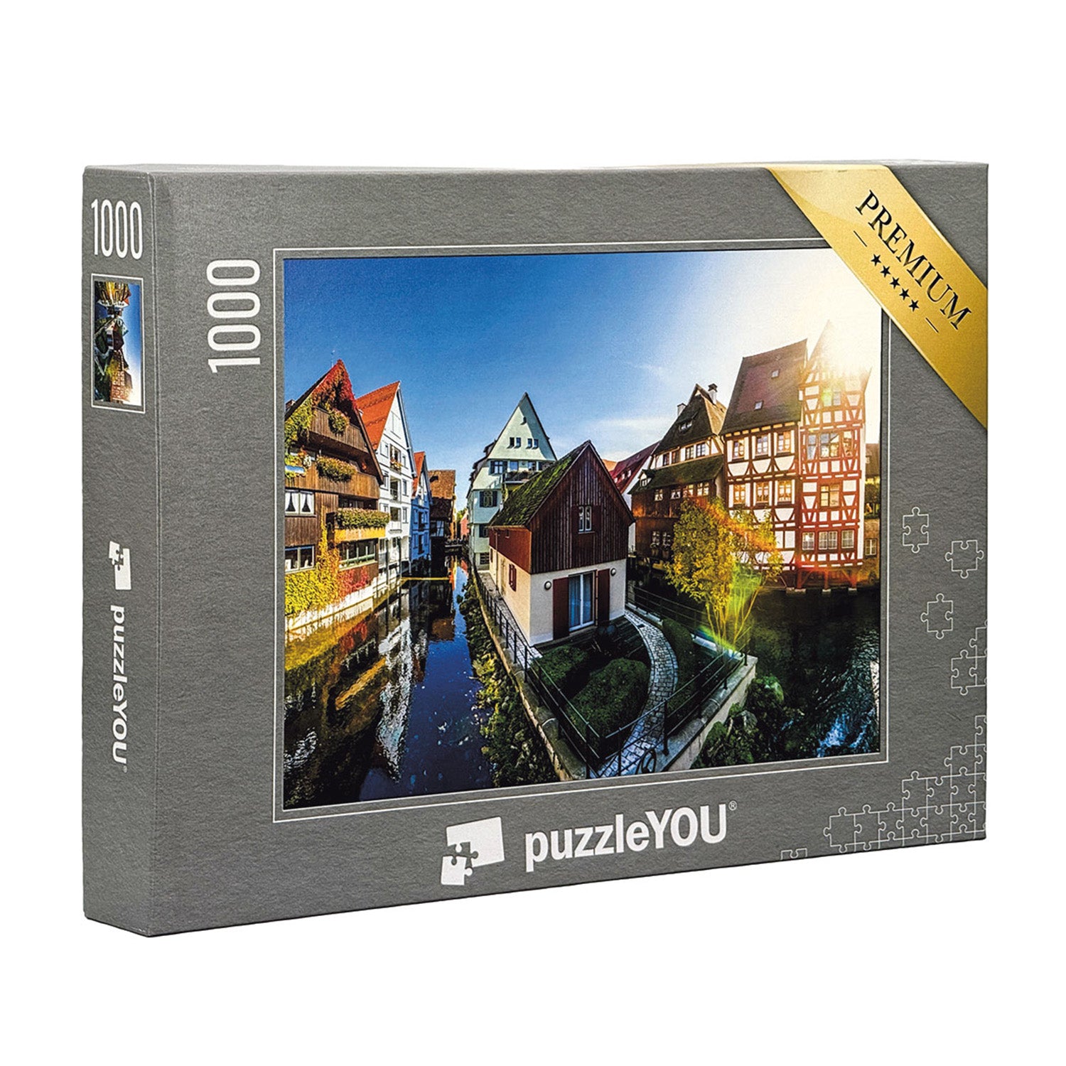 Das Puzzle Ulm Fischerviertel ist ein 1000-teiliges Set mit farbenfrohen historischen Gebäuden entlang eines Kanals, beleuchtet von hellem Sonnenlicht. Die graue Box mit dem goldenen Premium-Etikett macht es zum idealen Ulmer Souvenir.