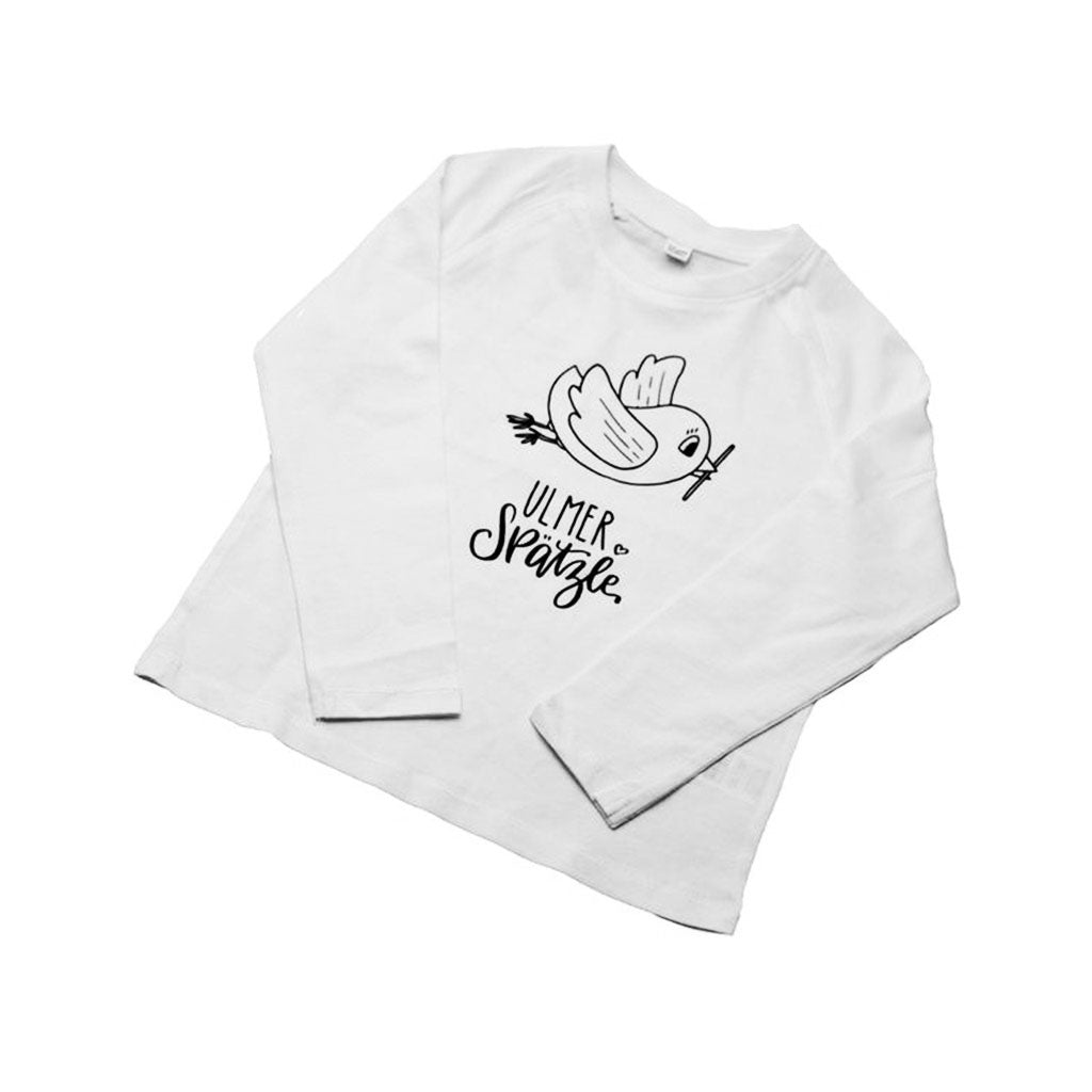 Das Shirt „Ulmer Spätzle“ für 4–5-Jährige hat ein weißes Langarmdesign mit einer einfachen schwarzen Vogelillustration und einem stilvollen, handgeschriebenen „Ulmer Spätzle“-Schriftzug darunter.