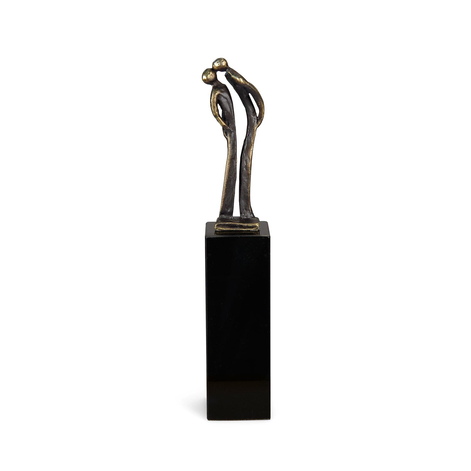 Die Skulptur „Der Kuss“ zeigt zwei abstrakte, längliche Bronzefiguren in zärtlicher Umarmung auf einem hohen, rechteckigen schwarzen Sockel. Ihre Köpfe neigen sich sanft zueinander, während sich die schimmernde Bronzeoberfläche vom schlichten weißen Hintergrund abhebt.