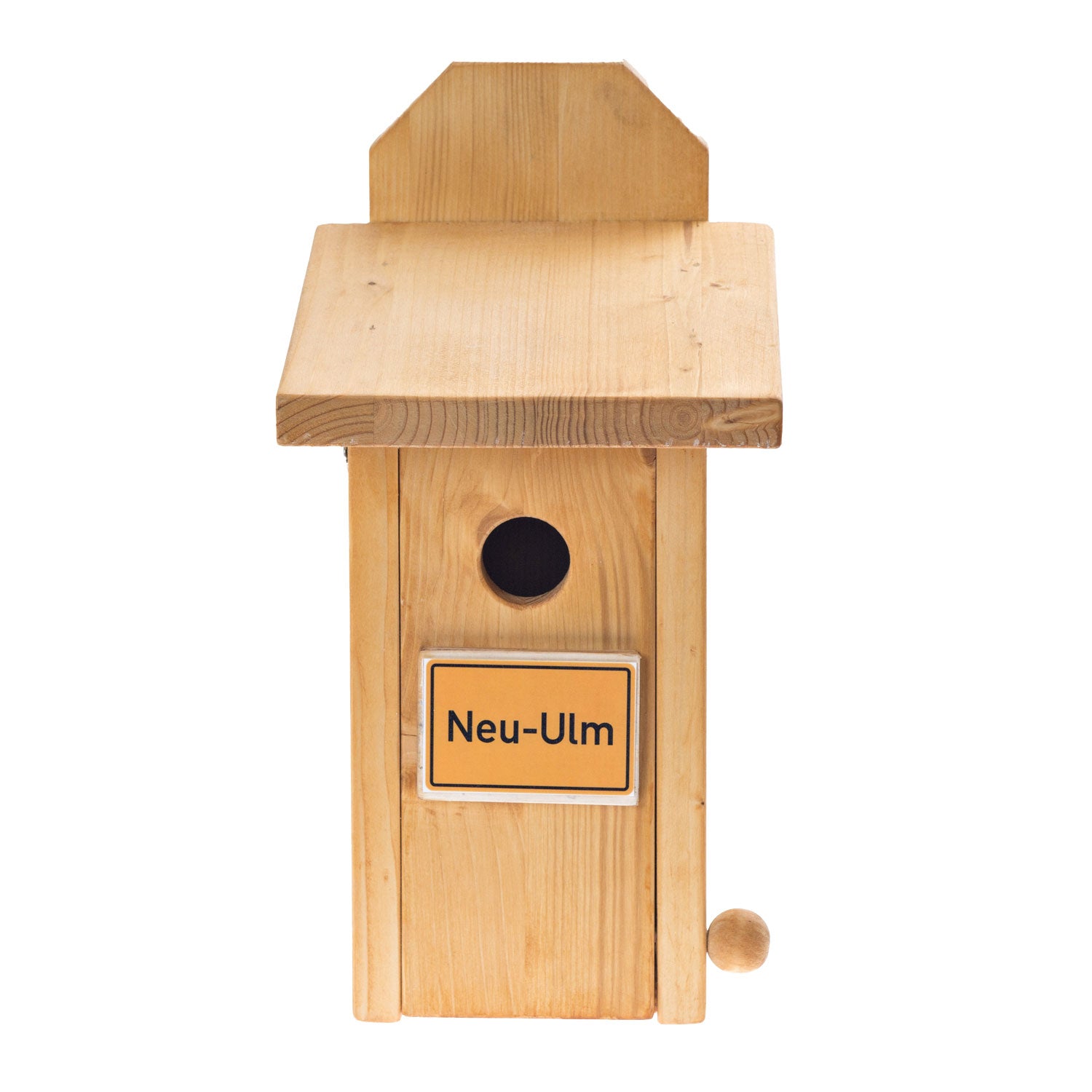 Das Vogelhaus mit Ortsname Neu-Ulm hat ein Flachdach, einen kleinen runden Eingang und ein gelbes „Neu-Ulm“-Schild an der Vorderseite. Sein modernes Design verbindet natürlichen Charme mit einem funktionalen Kugelzapfen, der die Natur unterstützt.