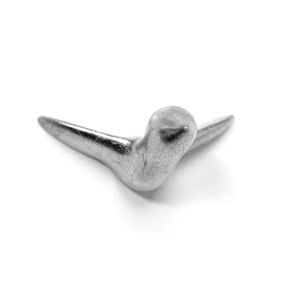 Die Wandskulptur Mini Vogel Silber ist eine handgefertigte Skulptur aus silbernem Beton, die einem stilisierten Vogel mit ausgebreiteten Flügeln ähnelt, von oben betrachtet und vor einem schlichten weißen Hintergrund platziert – ideal als einzigartiges Stück Wanddekoration.